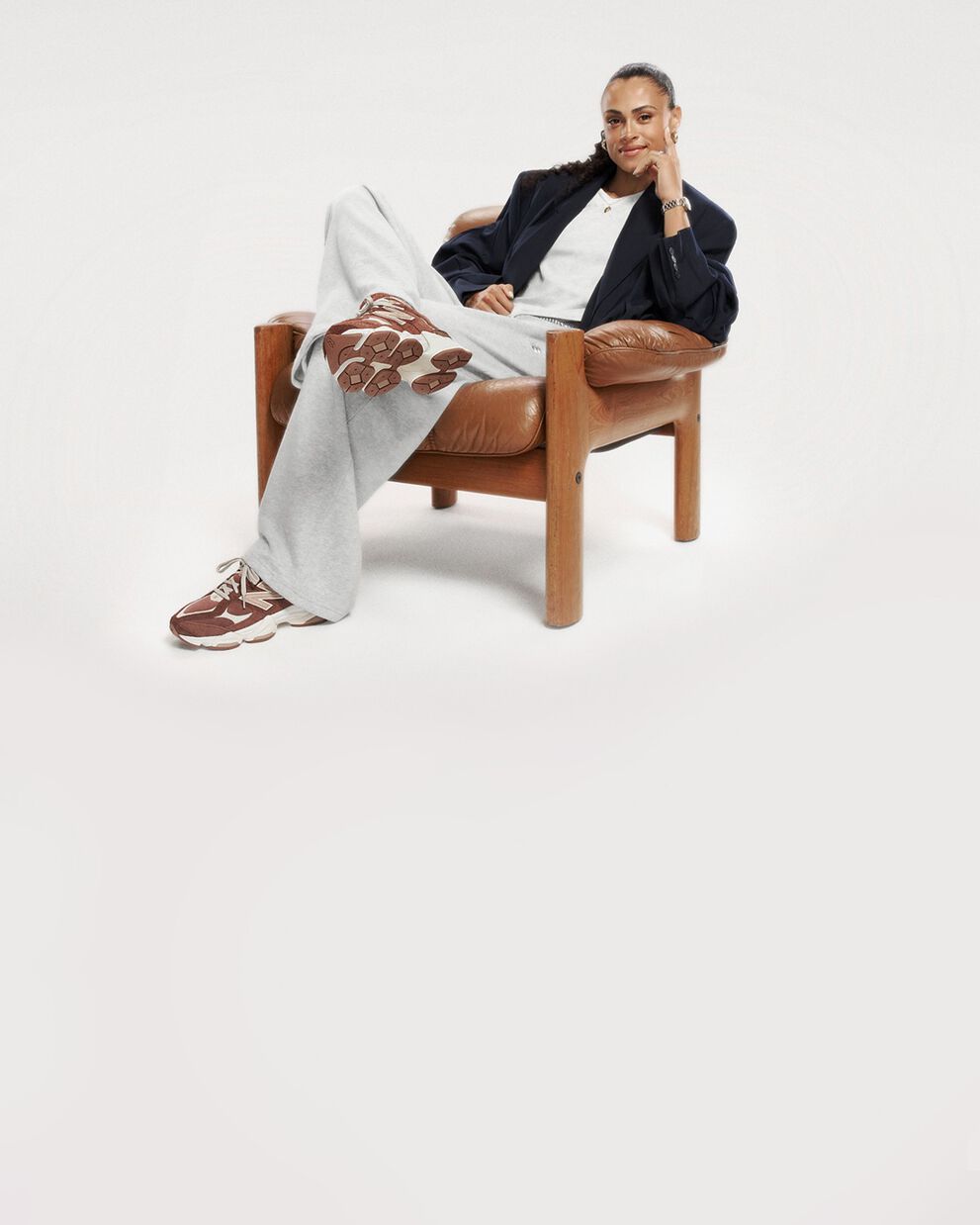 Pile of New Balance sneakers on beige background 